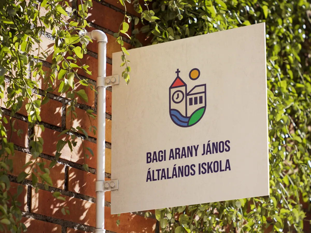 Kültéri információs tábla az iskola emblémájával, borostyános téglafalon